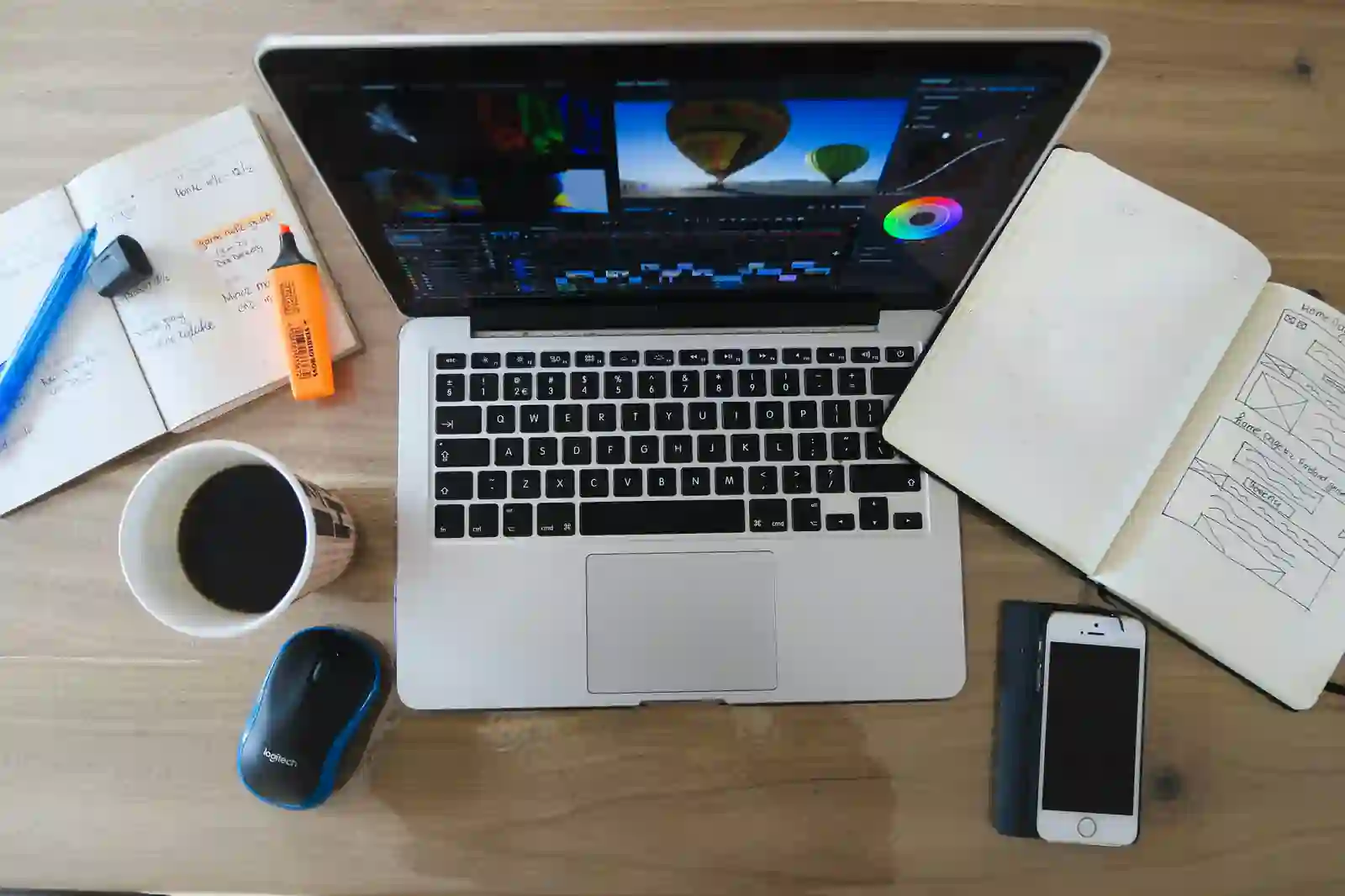 Escritorio de trabajo con laptop, cuaderno y materiales para organizar un proyecto.